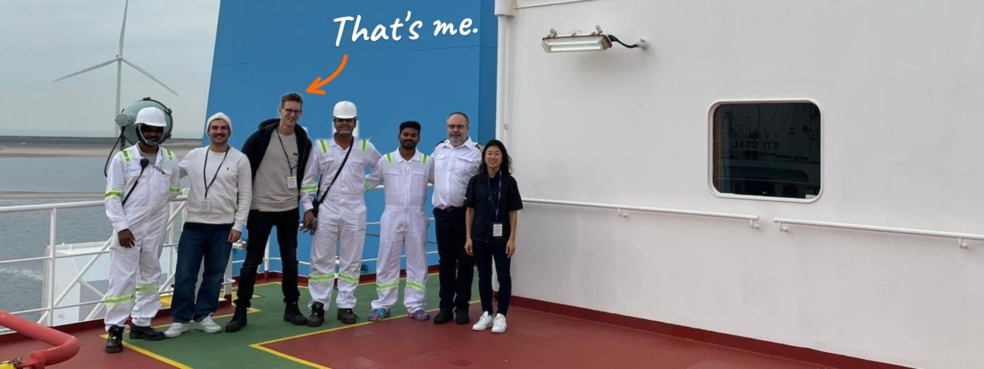 On deck of a tanker in the port of Rotterdam, with the crew. An arrow points to Joris: That's me.